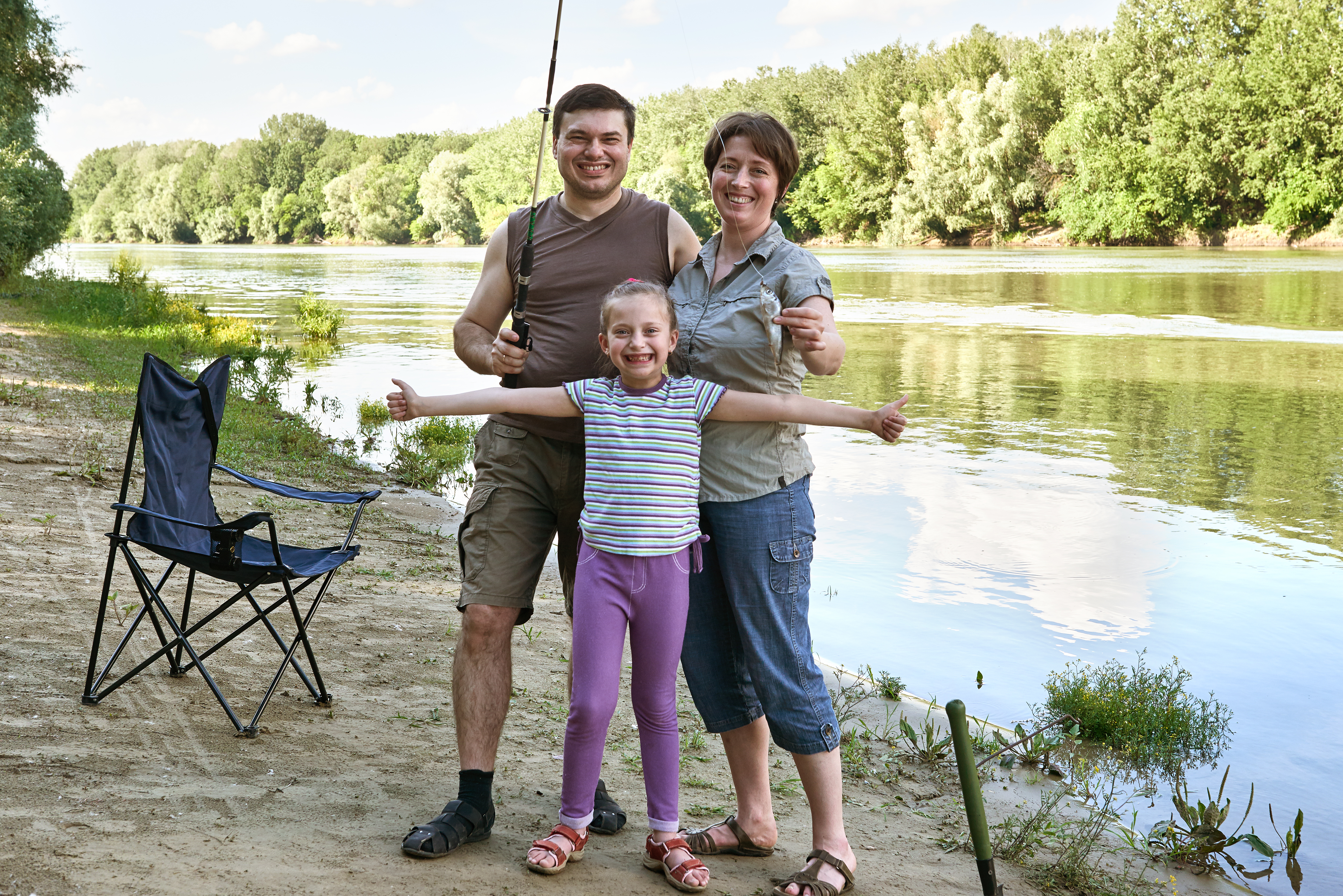 people camping and fishing, family active in nature, fish caught on bait, river and forest, summer season